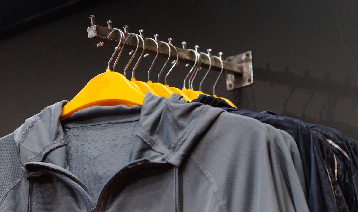  Closeup view of sports top wear on hangers in display of retail shop or store                               